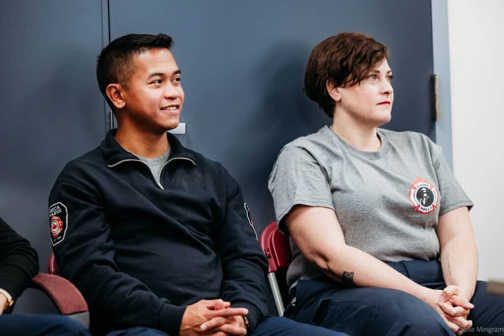 two camp molly trainers sitting and listening to the training session